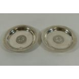 A pair of small circular silver coloured metal dishes,