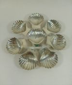 A set of eight Mexican shell-shaped butter dishes, each raised on three ball feet,