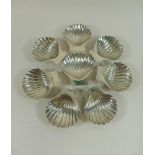 A set of eight Mexican shell-shaped butter dishes, each raised on three ball feet,