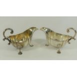 A pair of George IV silver sauce boats, London 1929, with shaped bodies, reeded rims,