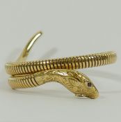 A 9 carat gold and sprung bangle in the form of a snake, Chester 1956, with gem set eyes, 21.