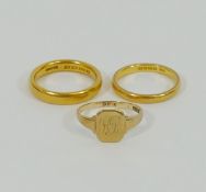 Two 22 carat gold wedding bands, combined weight 12.5g, and a 9 carat gold signet ring, 3.