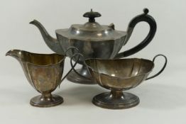 A George IV silver three piece pedestal teaset, Birmingham 1931, of oval form with shaped sides,