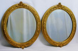 A pair of oval gilt framed mirrors, the