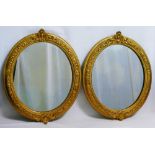 A pair of oval gilt framed mirrors, the