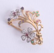 An 18ct flower brooch set with diamonds, ruby's, sapphires and emeralds marked '750 EWA', approx 5.