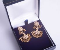 A pair of ornate Indian high carat gold and diamond set earrings.