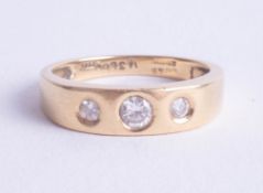 An 18ct diamond three stone ring, size O.