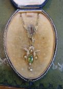 Edwardian 15ct peridot and seed pearl pendant on chain, cased.