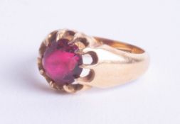 An 18ct ring set with a red coloured gemstone, approx. 6.5g