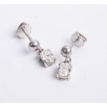 A pair of platinum and diamond drop earrings, set with oval cut diamonds.