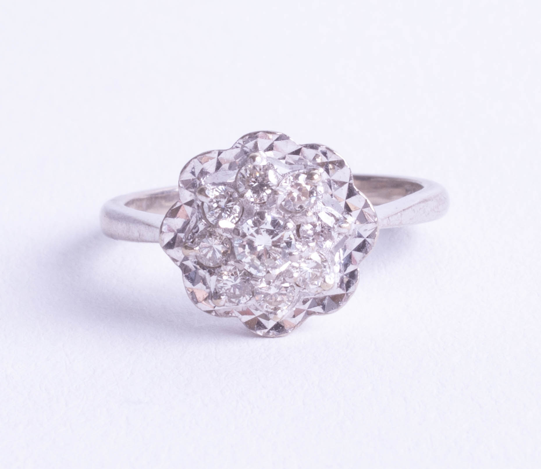 An 18ct white gold diamond illusion set cluster ring, ring size M.