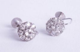 A pair of diamond cluster earrings set in white gold.
