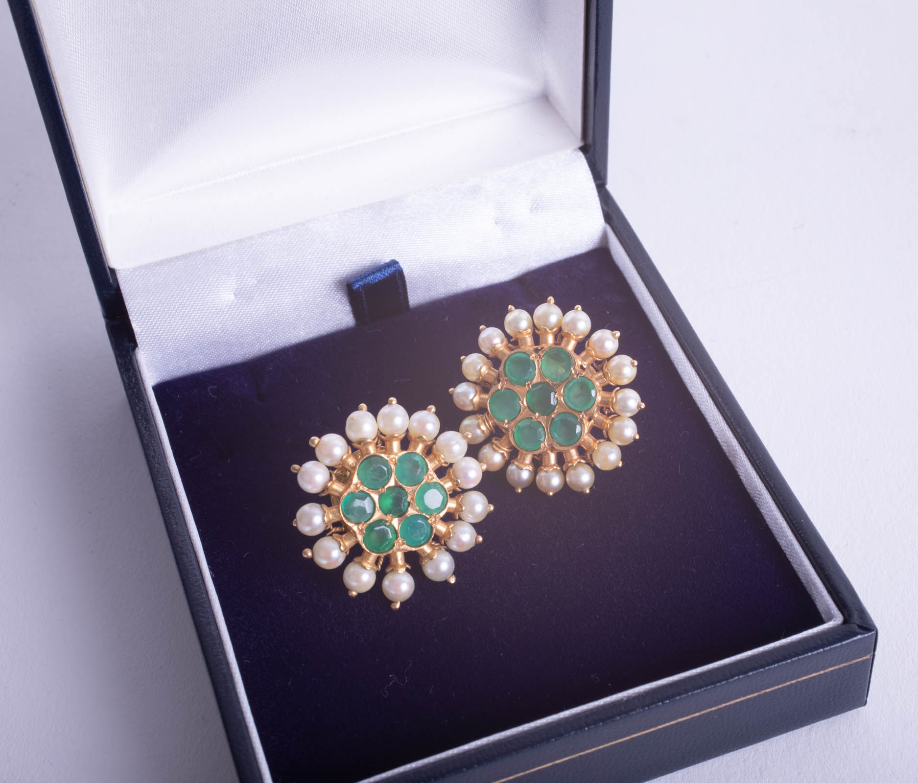 A pair of ornate Indian high carat gold emerald and pearl earrings.