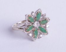 An 18ct emerald and diamond cluster ring, size M.