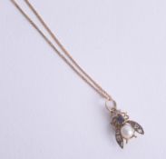An Edwardian diamond, sapphire and pearl set fly pendant on chain.