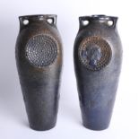 A pair of ceramic vases with portrait medallions, bronze effect glaze and handles, height 45cm.