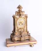 A heavy French gilt mantle clock with bell strike and pendulum with enamel cartouche dial, ornate