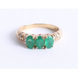 An 18k yellow gold emerald and diamond ring, size O.