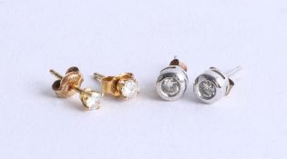 Two pairs of diamond stud earrings.
