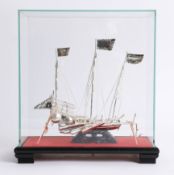 A 20th century white metal Chinese boat in glass case, possibly Wang Hing.