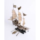 A Chinese silver model of a ship on carved wood base, signed, height 25cm.