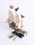 A Chinese silver model of a ship on carved wood base, signed, height 25cm.