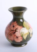 A Moorcroft green hibiscus vase, height 14cm with label.