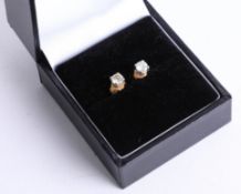 A pair of diamond stud earrings.