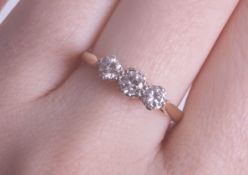 An 18ct diamond three stone ring, size N.