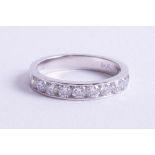 An 18ct white gold and diamond set half band eternity ring, size M.