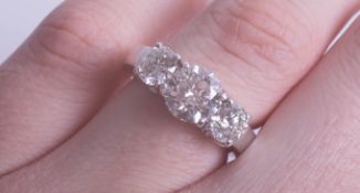 A fine three stone diamond ring, platinum mount, total diamond weight approx 2.75 cts, judged to