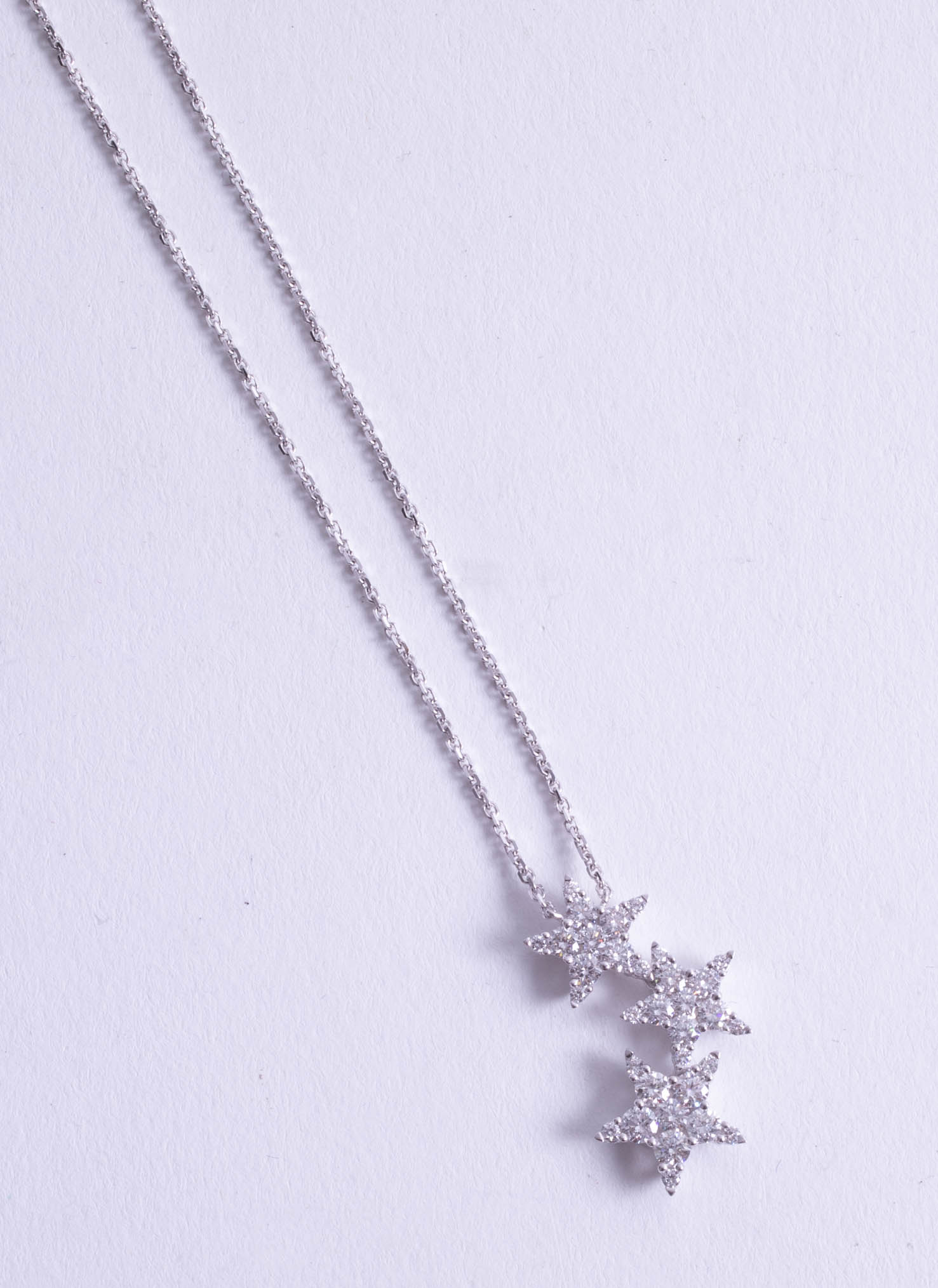 An 18ct diamond three star pendant.