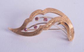An 18ct stylish brooch set with rubies, approx 7.80g.