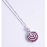 An 18ct ruby and diamond set pendant of swirl contemporary design.