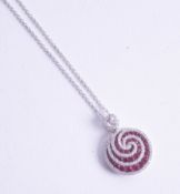 An 18ct ruby and diamond set pendant of swirl contemporary design.