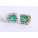 A pair of emerald and diamond cluster earrings set in 18ct yellow gold, the emerald cut emeralds
