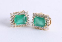 A pair of emerald and diamond cluster earrings set in 18ct yellow gold, the emerald cut emeralds