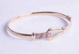 A 9ct diamond and ruby set bangle.