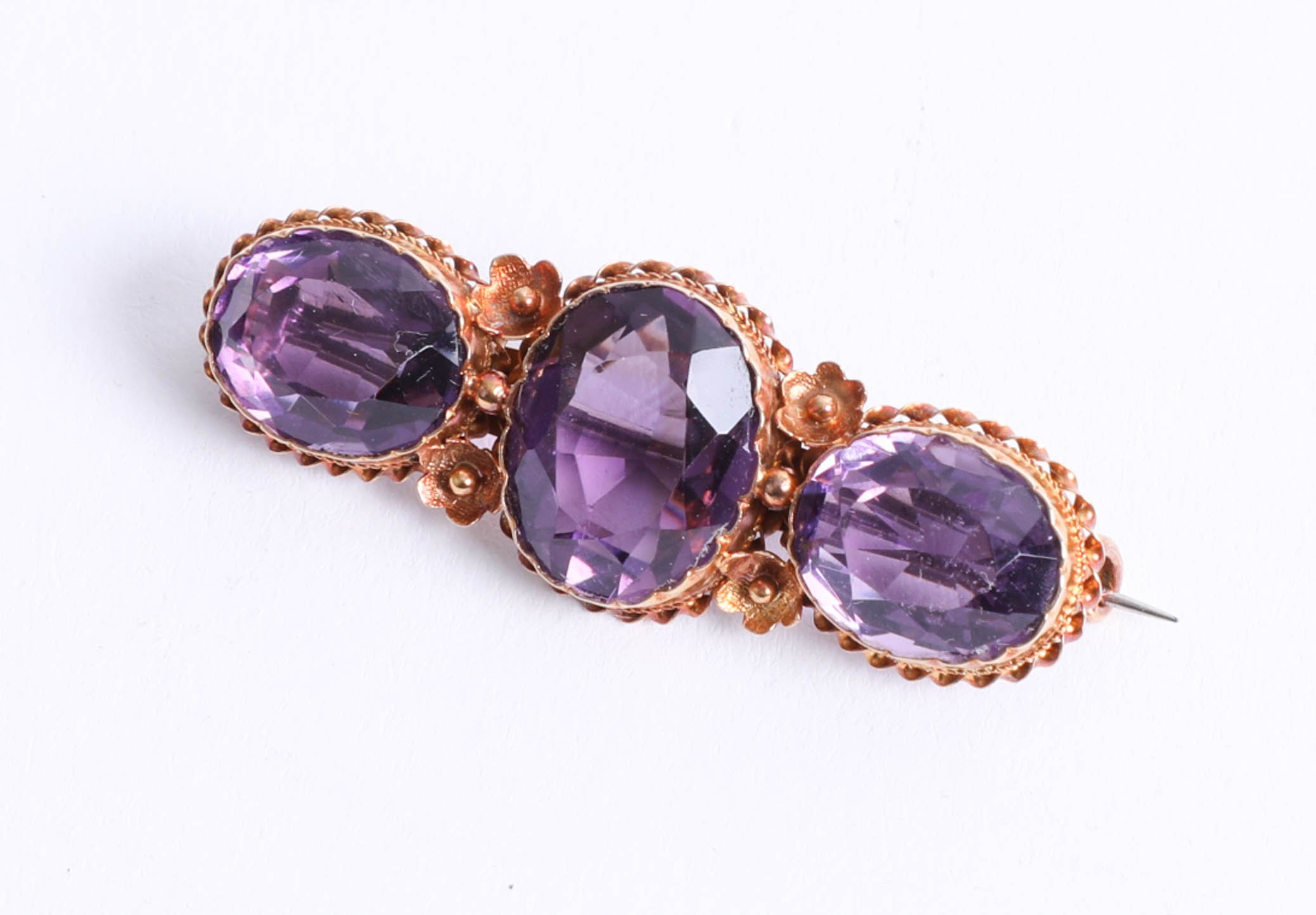 A 15ct amethyst three stone bar brooch, 5.50g.