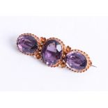 A 15ct amethyst three stone bar brooch, 5.50g.