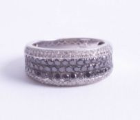 A 14ct black and white diamond set dress ring, size P/Q.