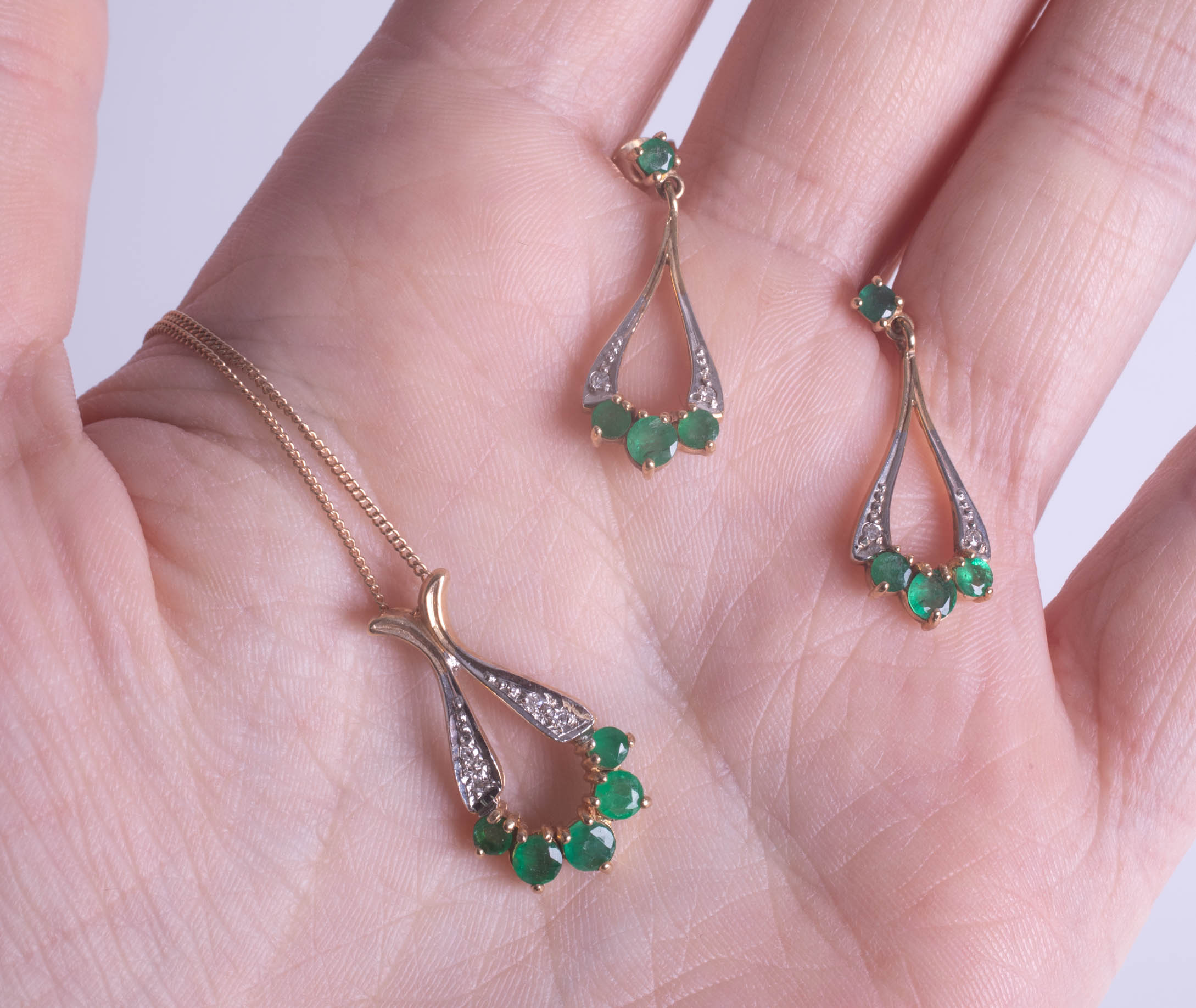 A 9ct emerald and diamond pendant and earring set.