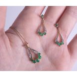 A 9ct emerald and diamond pendant and earring set.