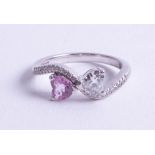 An 18ct heart shaped diamond and pink sapphire ring, size M.