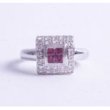 An 18ct white gold ruby and diamond ring of square design, size O.