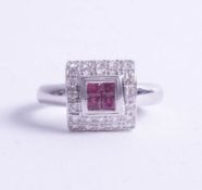 An 18ct white gold ruby and diamond ring of square design, size O.