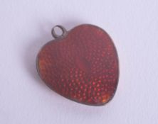 A gold enamel heart-shaped pendant.