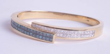 An 18k yellow gold bangle set with blue and white diamonds, approx 41.60g, purchased in 2007 for £