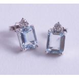 A pair of 18ct white gold diamond and aquamarine (emerald cut) earrings.